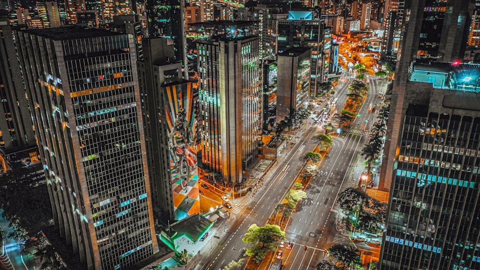 Illuminated city skyline showcasing bustling urban nightlife from a high viewpoint.