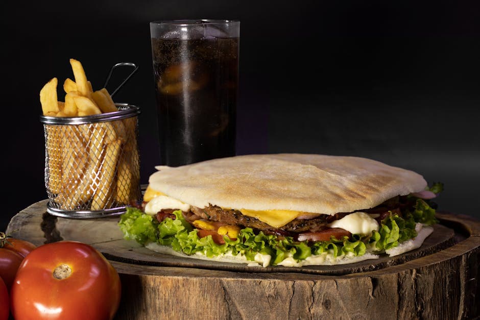Mouthwatering burger served with fries and cold soda on a rustic wooden board in São Paulo, Brazil.