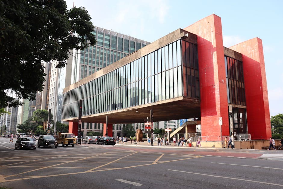 Traffic passes by the iconic São Paulo Museum of Art on a bustling city day.