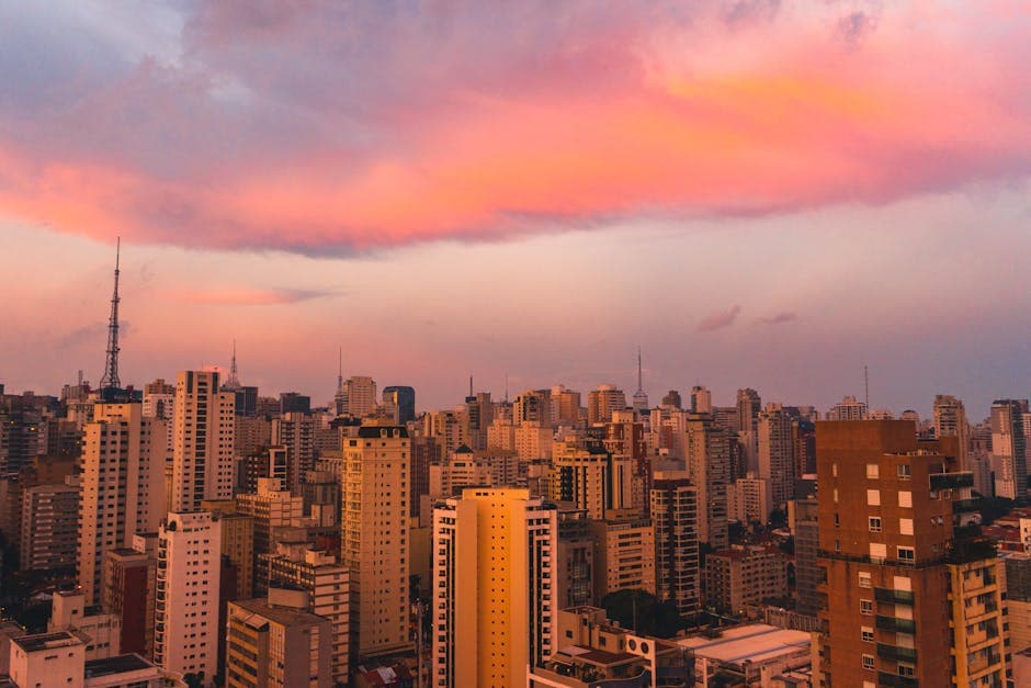 A breathtaking view of São Paulo's skyline at dusk, featuring vibrant pink and orange clouds.