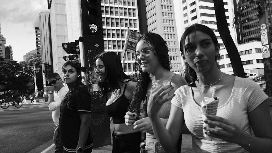 Young adults crossing street in urban setting, enjoying ice cream.
