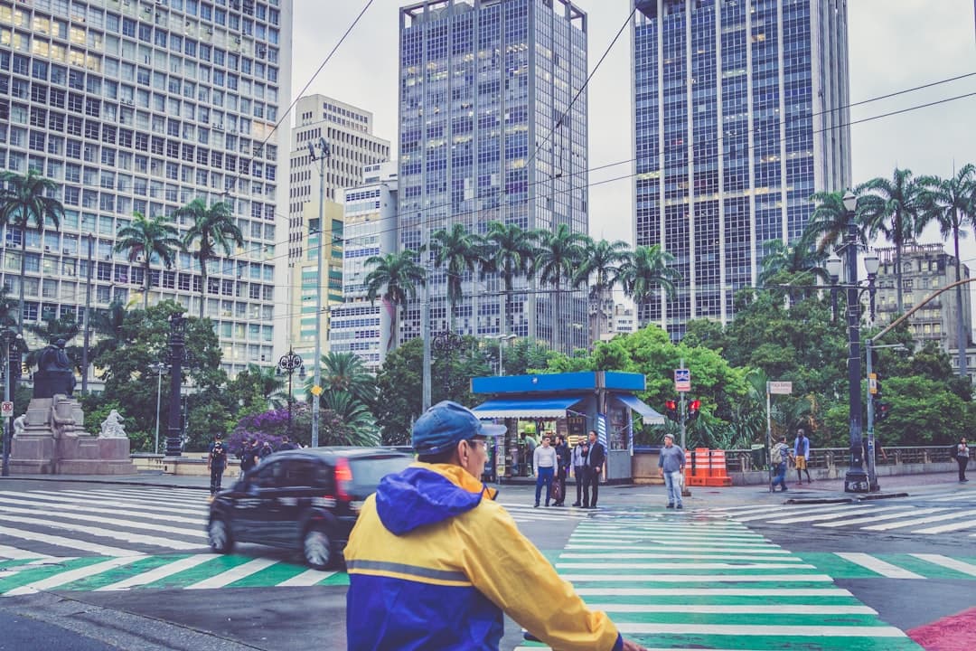 man wearing yellow and blue raincoat near street during daytime