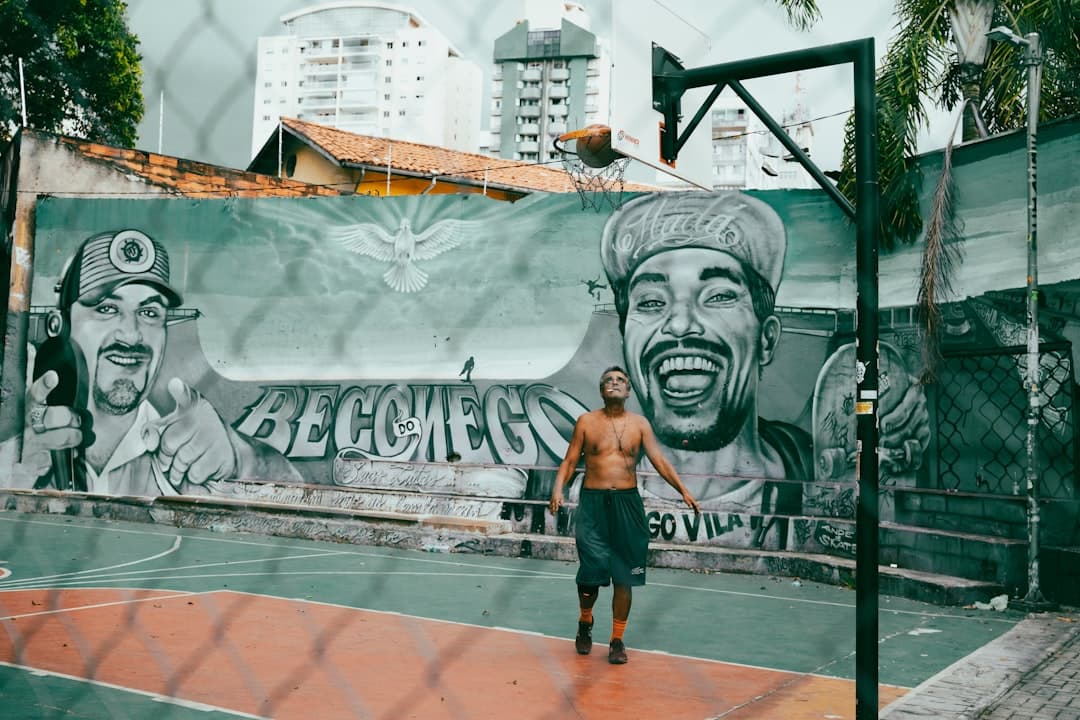 a man standing in front of a wall with a mural of a man