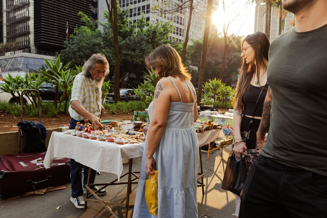 A group of people standing around a table with food on it