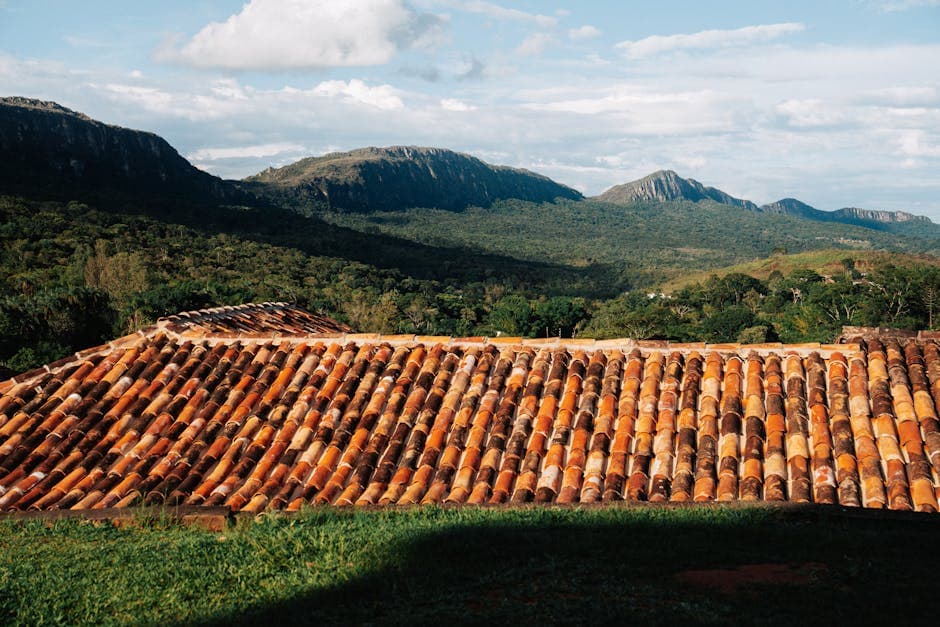 Rustic tiled rooftop with mountain backdrop in Tiradentes, MG, Brazil.