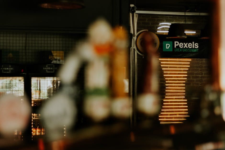 Warm ambiance of a pub with blurred focus, showcasing a Pexels Creators Summit sign.