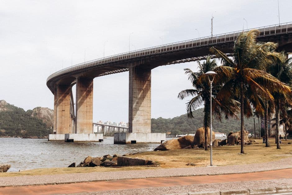 Scenic view of the iconic Third Bridge in Vitória, Brazil, captured on a clear day alongside palm trees and the coastline.