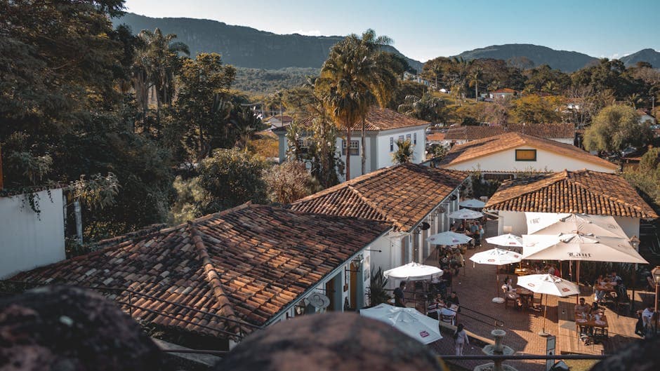 Scenic aerial shot of Tiradentes, Brazil, showcasing an outdoor restaurant and mountain backdrop.