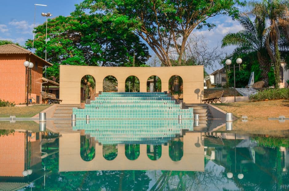 Beautiful reflection of an amphitheater with arches in Nova Veneza, Brazil, surrounded by lush greenery.