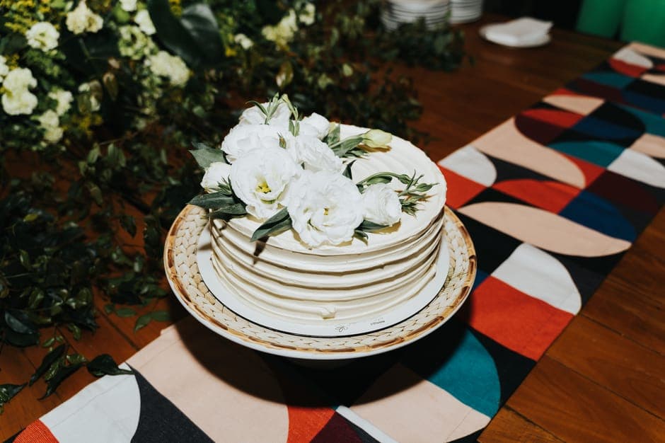 Beautiful white floral cake on a colorful table setting, perfect for celebrations.