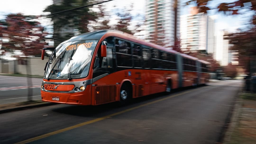 A red bus is speeding down a road.