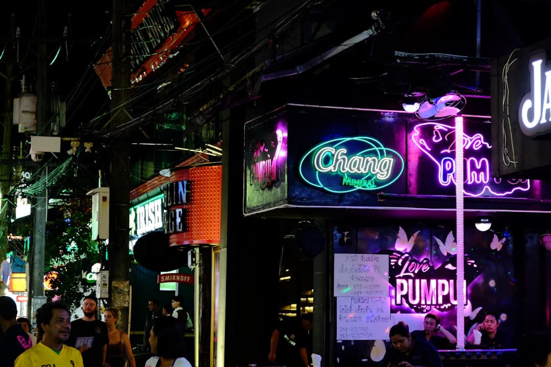 a group of people walking down a street at night
