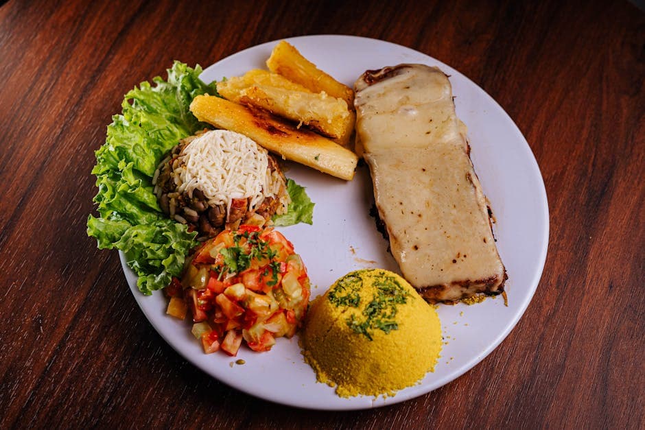 A mouthwatering plate of Brazilian cuisine with cheese, rice, salad, and fried yuca.