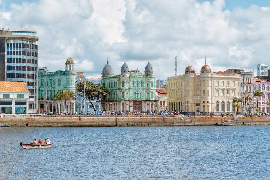 Vibrant cityscape of Recife's historic waterfront buildings under a cloudy sky.
