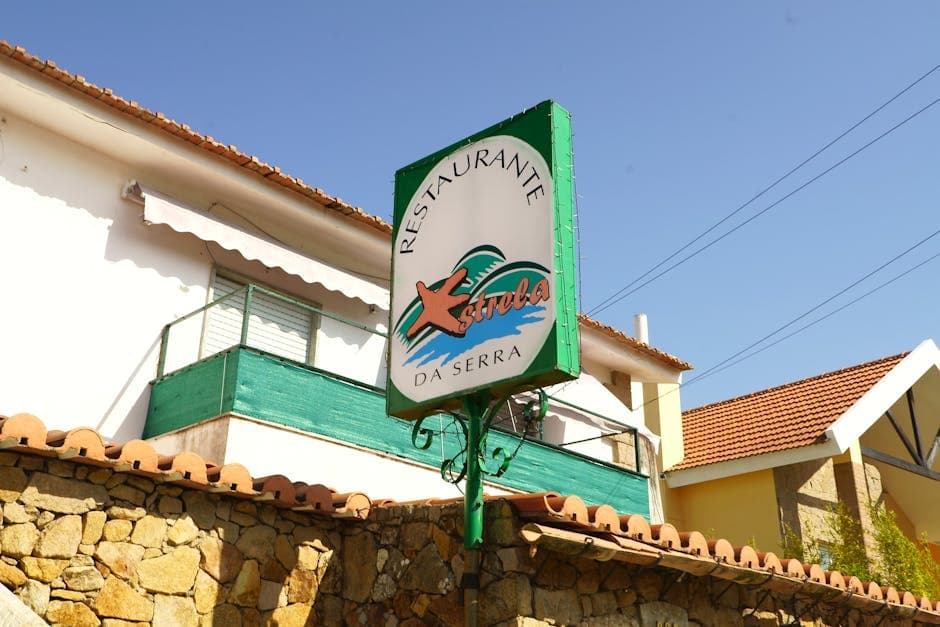 Signage of Restaurante Estrela da Serra on a sunny day in Lisbon, Portugal.
