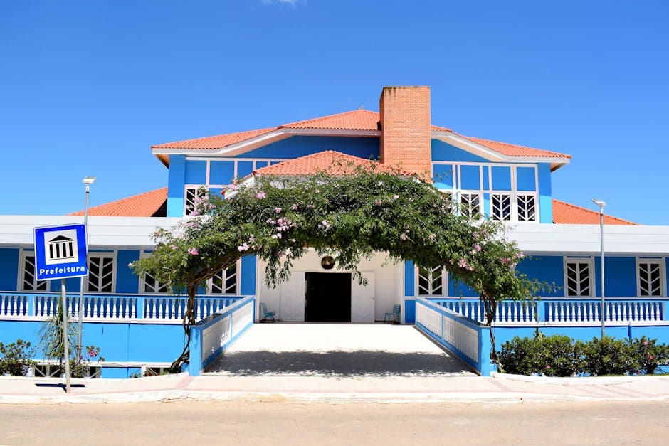 A vibrant blue government building in Santa Maria de Jetibá, Espírito Santo under clear skies.