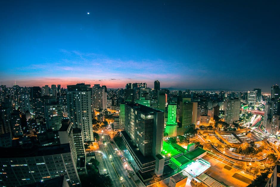 A vibrant twilight view of the São Paulo skyline showcasing illuminated skyscrapers and bustling streets.