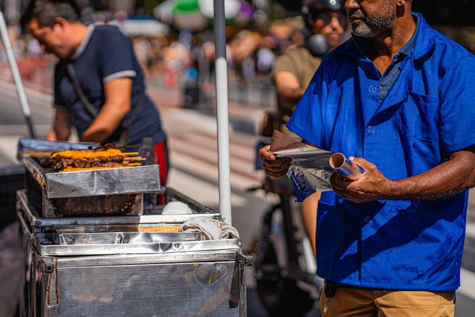 Street vendor grilling skewers on a sunny day in São Paulo, capturing vibrant street life.