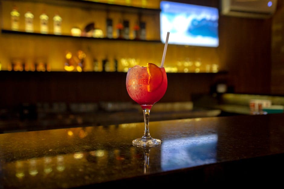 Chic cocktail glass on a polished bar counter in a warm-lit indoor setting.