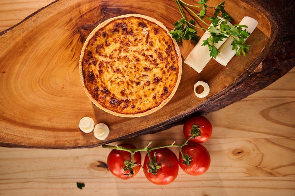 Mouthwatering cheese quiche on wooden board with tomatoes and parsley garnish, perfect for culinary themes.