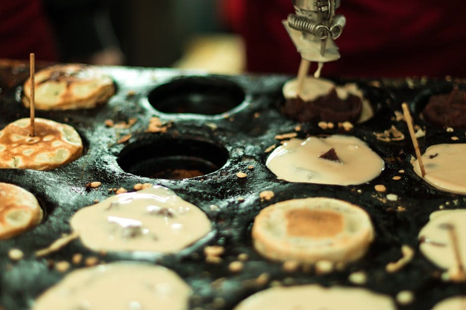 Close-up of Brazilian street food pancakes being prepared on a griddle in São Paulo.