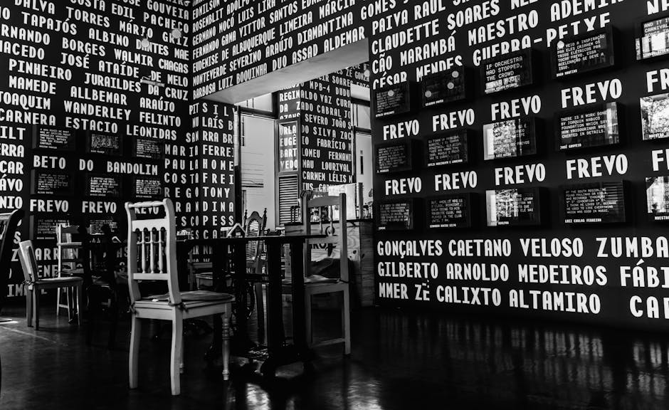 Monochrome view of Recife's Frevo Museum featuring empty tables and chairs.