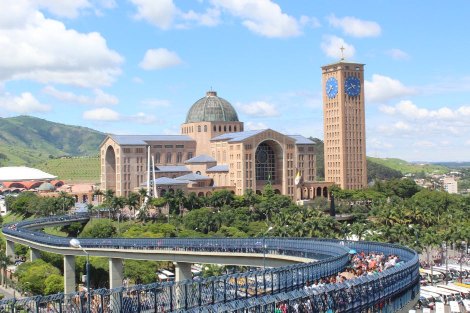 A sweeping view of the Basilica of Nossa Senhora Aparecida surrounded by lush greenery and hills.