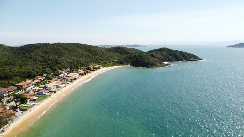 Aerial view of the beautiful coastline at Loteamento Triangulo de Buzios, Rio de Janeiro, Brazil, featuring lush greenery and blue waters.