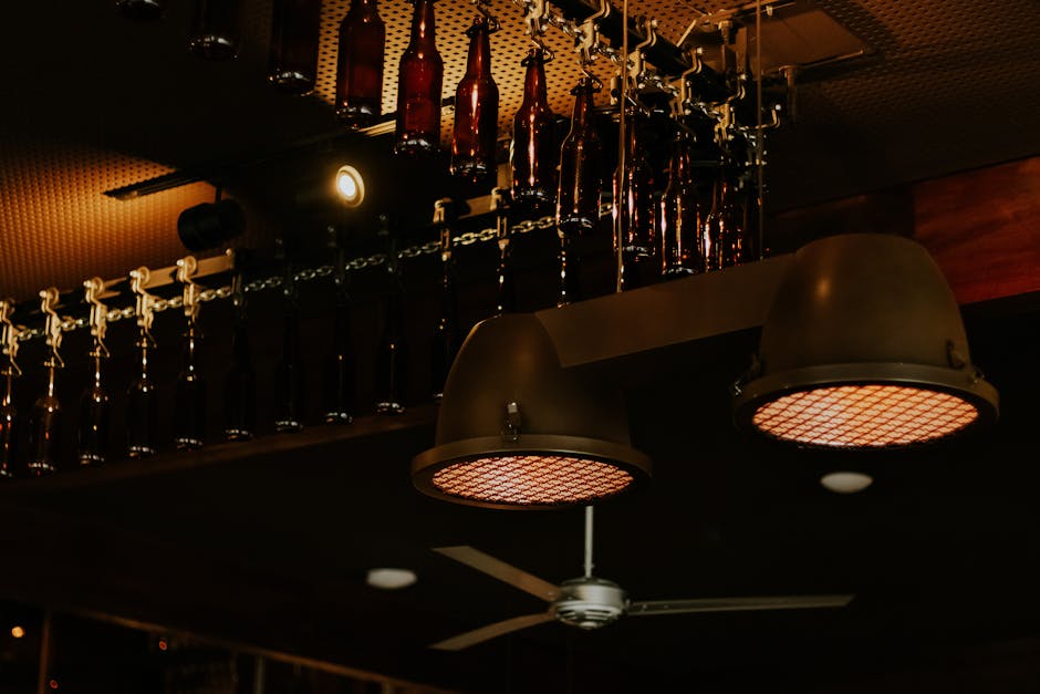 Industrial style ceiling lights and bottles create a moody ambiance in a São Paulo bar interior.