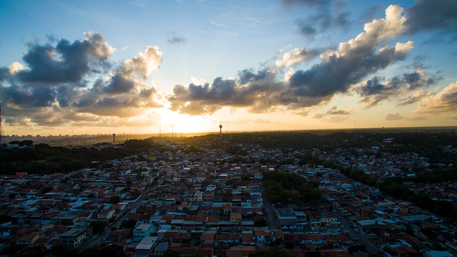 Stunning aerial view of Recife, Brazil at sunset with dramatic clouds and warm hues.