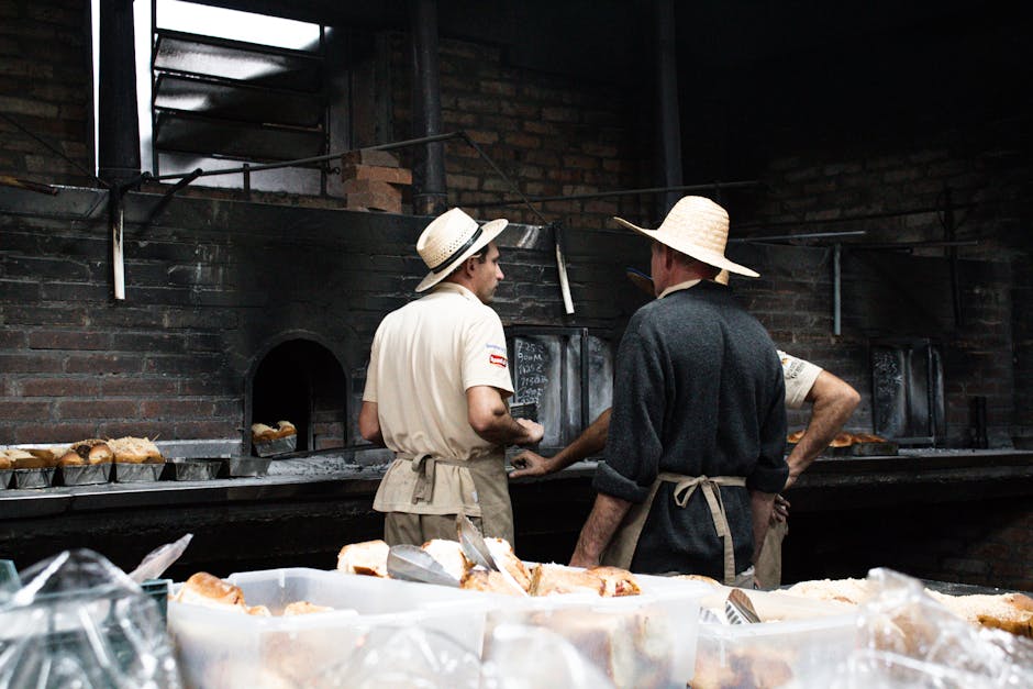 Bakers work together in a rustic setting with a wood-fired oven in Gramado, Brazil.