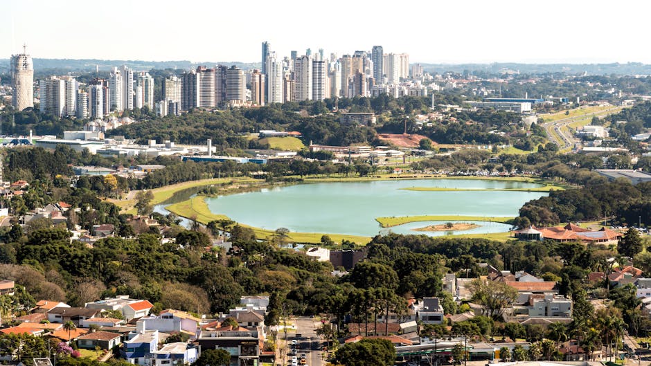 Aerial view of Curitiba skyline with Barigui Park Lake, showcasing urban nature blend.