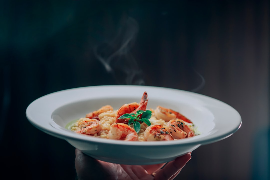 person holding white ceramic bowl with food
