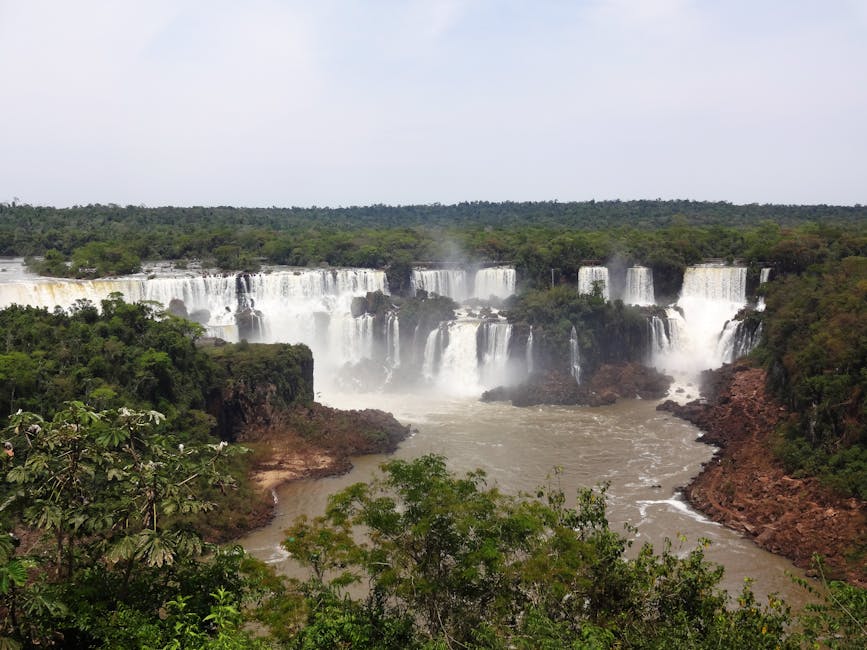 Explore the majestic Iguazu Falls at Foz do Iguaçu, Brazil, amid lush tropical landscapes.