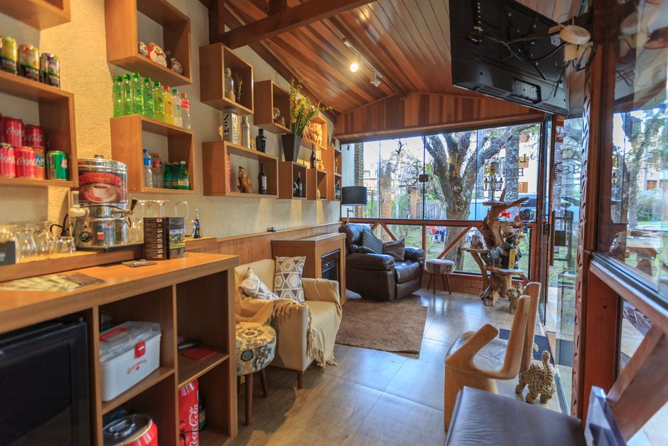 Warm and inviting café interior with armchairs, shelves, and outdoor view.
