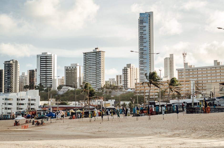 Skyline of Natal featuring skyscrapers and a vibrant beach scene with palm trees.