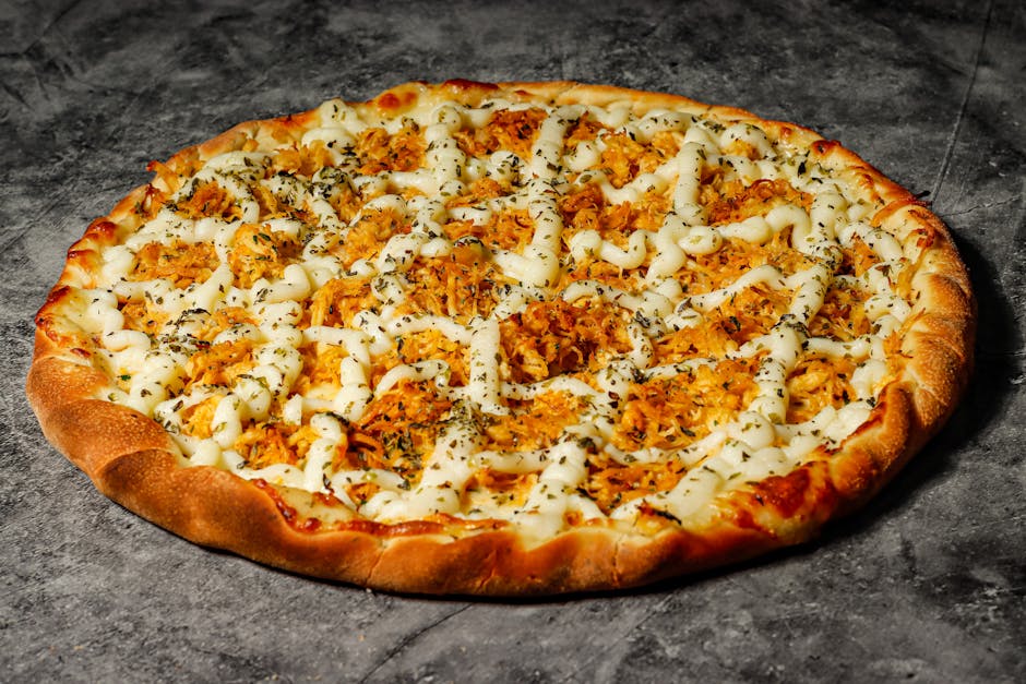 Close-up of a chicken pizza topped with herbs and cheese on a rustic surface.