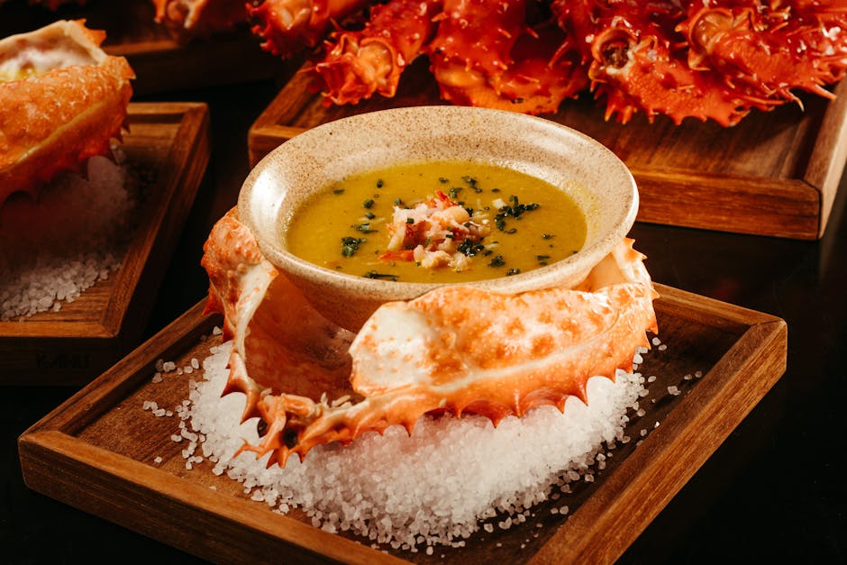 Gourmet crab soup served in its shell on a salt bed, highlighting culinary elegance.