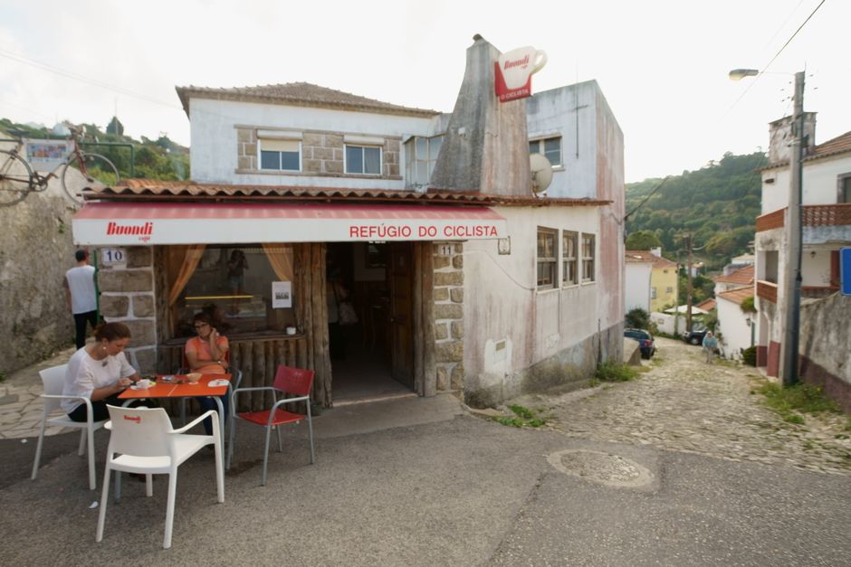 Outdoor seating at a quaint cafe in a Portuguese village, perfect for tourists exploring the area.