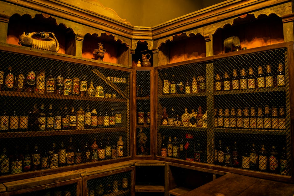 A collection of vintage liquor bottles displayed on rustic wooden shelves with wire mesh in a dimly lit room.