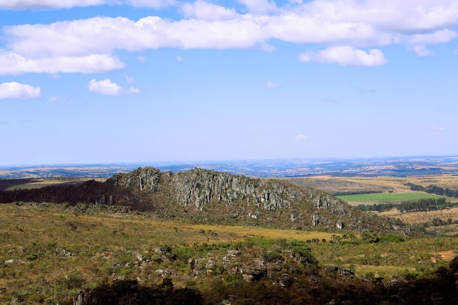 Expansive view of Morro do Cabeludo rock formation in Brazil's summer countryside.