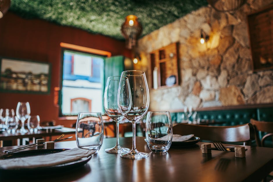 Elegant restaurant setting with glassware and stone walls in Tiradentes, Brazil.