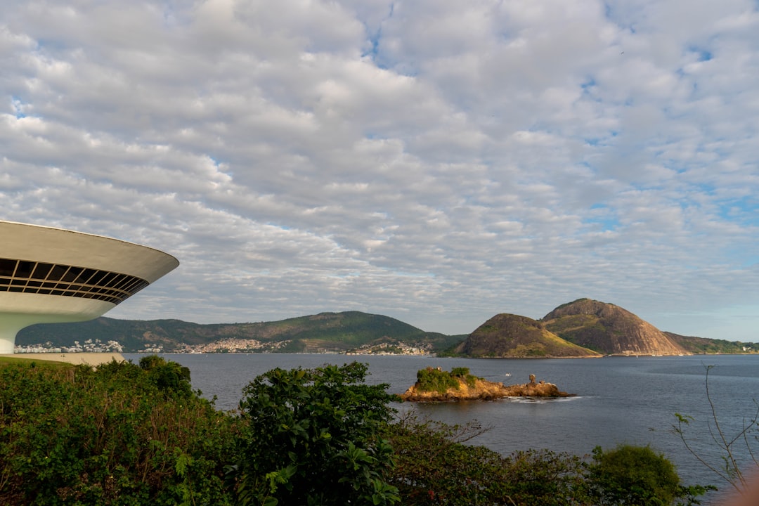 Modern building overlooking a bay with mountains