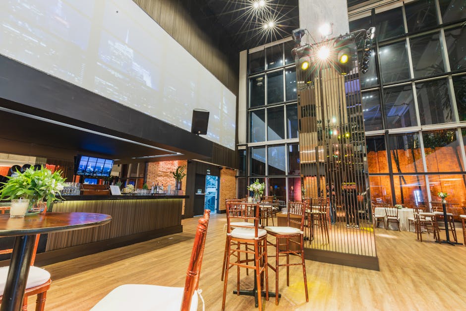 Stylish and elegant restaurant interior featuring a modern bar, decorative lighting, and sleek furniture setup.