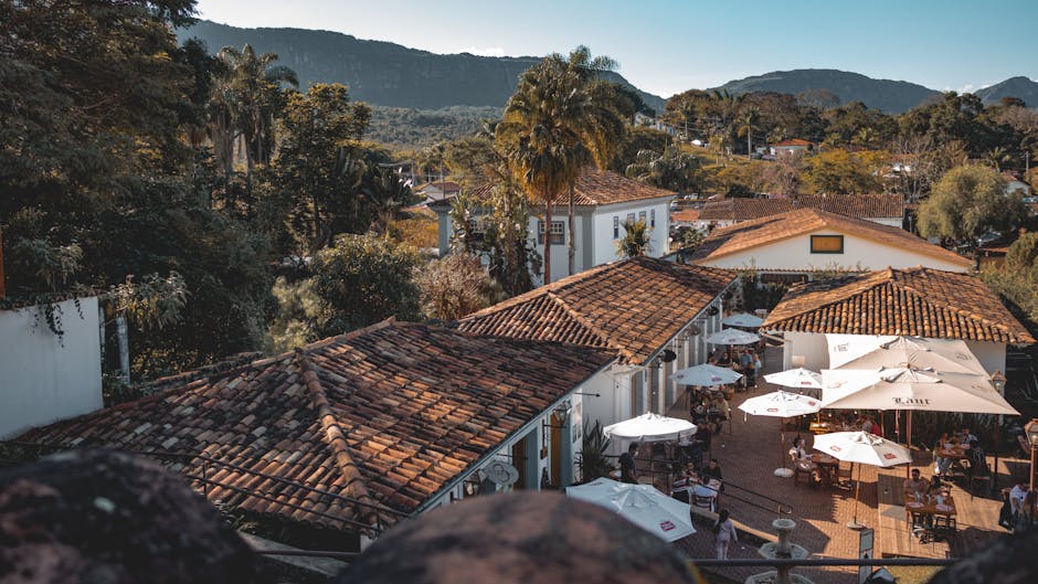 Scenic aerial shot of Tiradentes, Brazil, showcasing an outdoor restaurant and mountain backdrop.