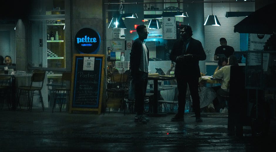 Moody and atmospheric street view of a bustling nighttime restaurant scene.