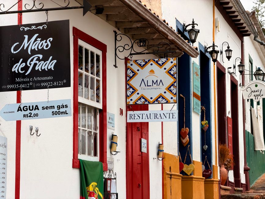 Colorful storefronts with artistic signs in a quaint street setting, evoking a vibrant atmosphere.