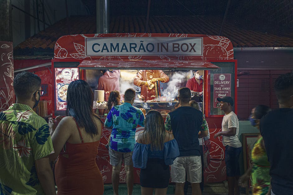 Crowds gather at a shrimp food truck in Porto de Galinhas for nighttime street food delight.