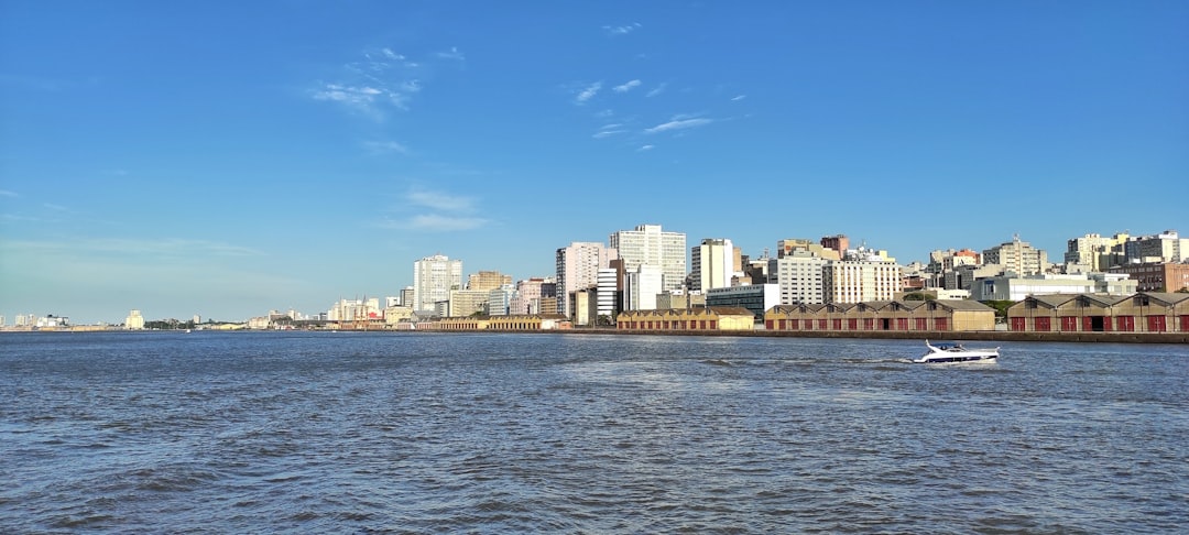 a boat traveling down a river next to a city