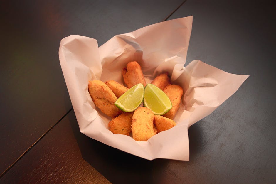 Delicious Brazilian snacks served with fresh lime wedges in a paper basket. Perfect for food photography.